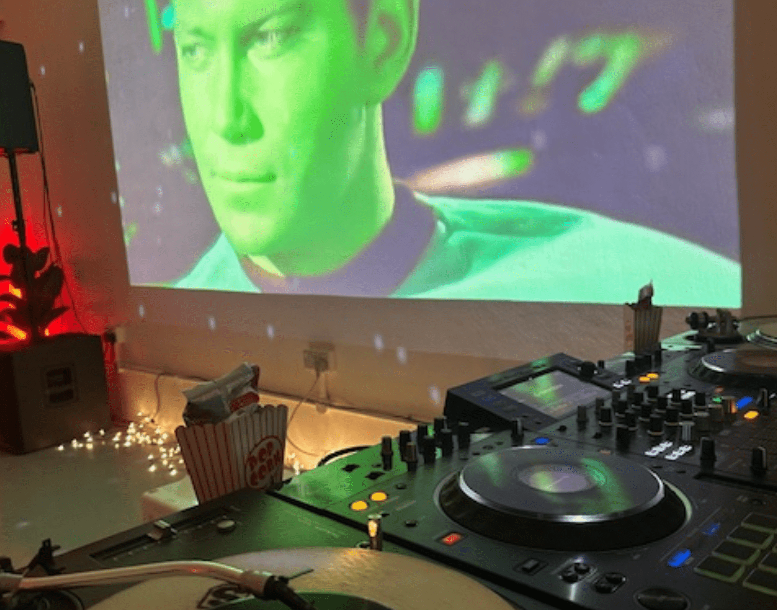 a vinyl record spins in a room with disco lights on a wall there's a projected image of Kirk from Star Trek