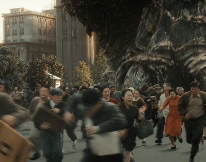 People flee from Godzilla on a Japanese city street