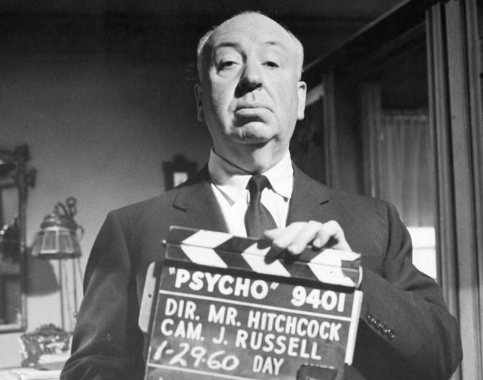 Alfred Hitchcock with a clapperboard